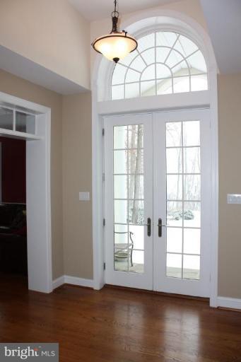 2124 Dixon Road Frederick, MD 21704 - Photo 5 of 30 an empty room with wooden floor chandelier and windows