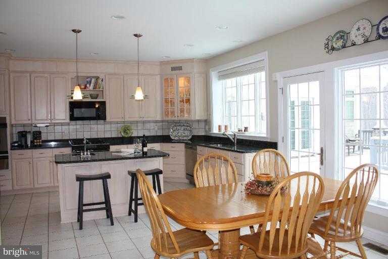 2124 Dixon Road Frederick, MD 21704 - Photo 8 of 30 a large kitchen with kitchen island granite countertop a stove a sink a dining table and chairs