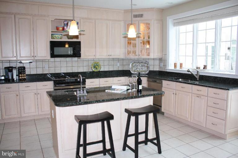 2124 Dixon Road Frederick, MD 21704 - Photo 9 of 30 a kitchen with stainless steel appliances granite countertop a sink a stove a microwave a counter space and cabinets