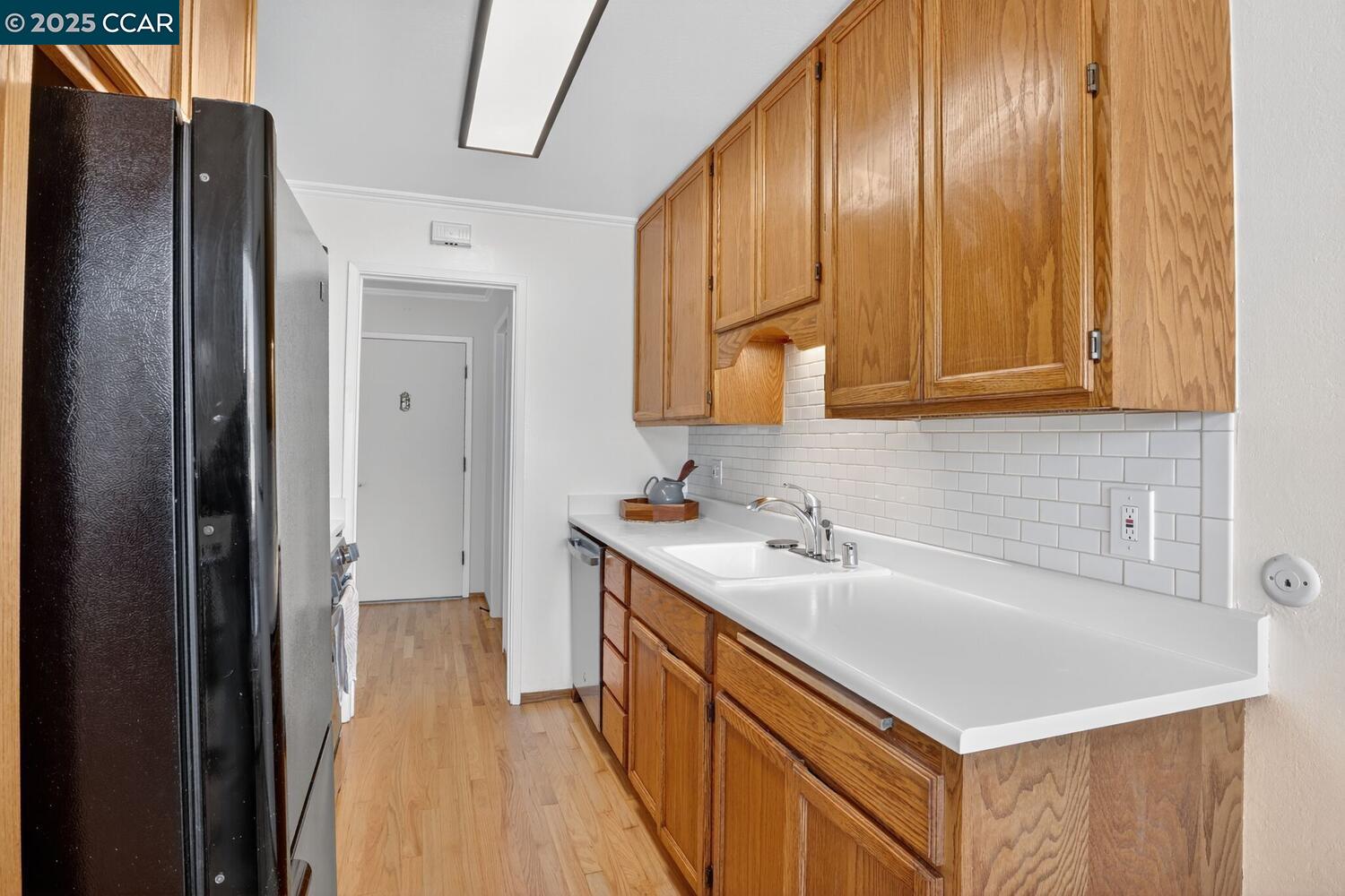 1601 Broadway, Unit 9 Alameda, CA 94501 - Photo 11 of 30 a kitchen with a sink a refrigerator and cabinets