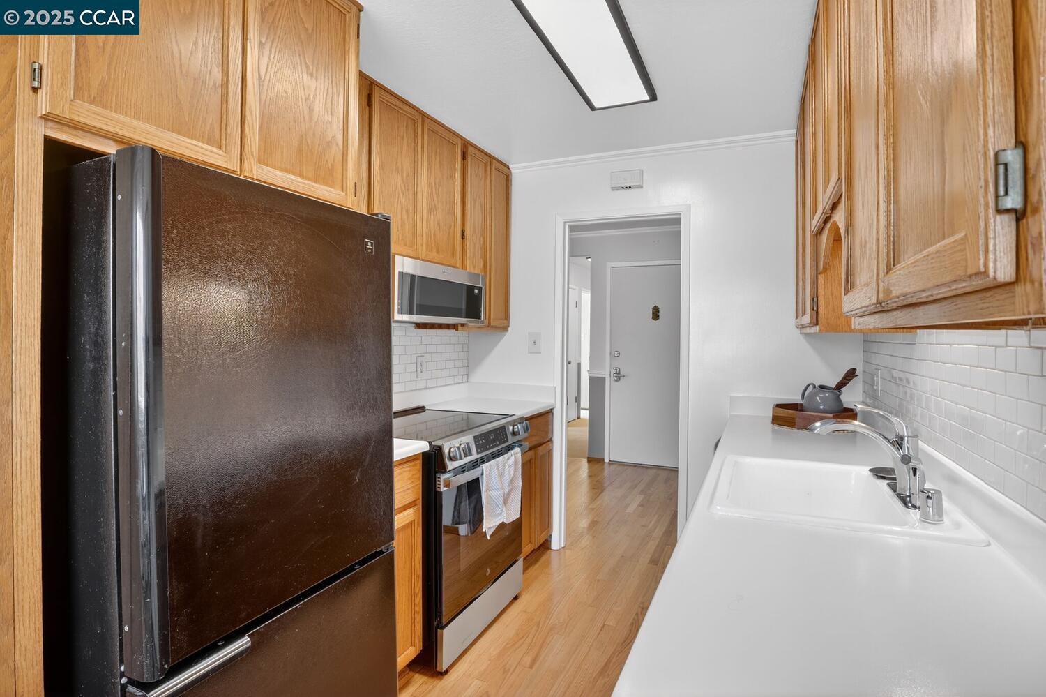 1601 Broadway, Unit 9 Alameda, CA 94501 - Photo 12 of 30 a kitchen with stainless steel appliances granite countertop a refrigerator a stove and a sink with large window