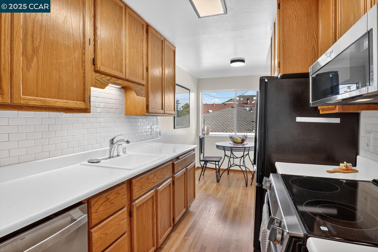 1601 Broadway, Unit 9 Alameda, CA 94501 - Photo 10 of 30 a kitchen with stainless steel appliances a sink a stove a table and chairs