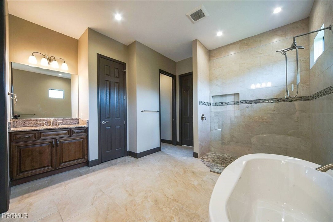 6142 Calusa Rdg Trail Bokeelia, FL 33922 - Photo 15 of 43 a bathroom with a tub sink shower and mirror