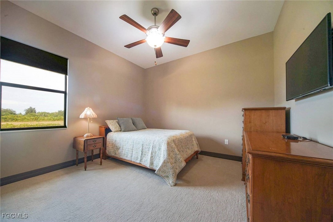 6142 Calusa Rdg Trail Bokeelia, FL 33922 - Photo 17 of 43 a bedroom with a bed window and a flat screen tv