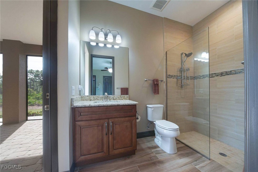 6142 Calusa Rdg Trail Bokeelia, FL 33922 - Photo 20 of 43 a bathroom with a granite countertop toilet a sink and a shower