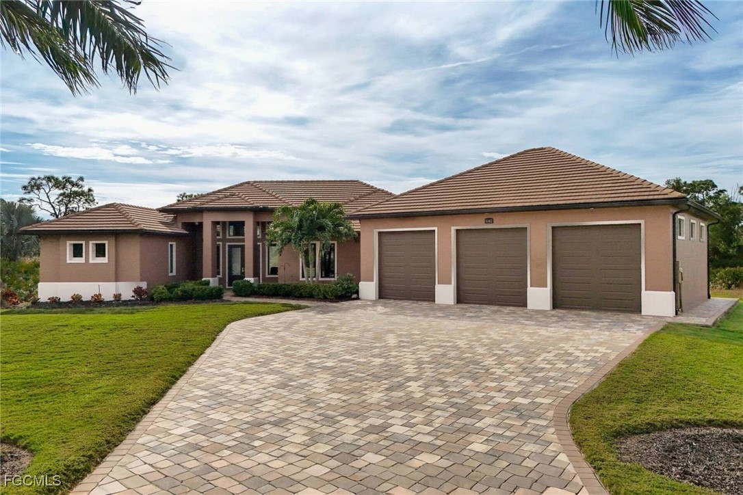 6142 Calusa Rdg Trail Bokeelia, FL 33922 - Photo 2 of 43 a front view of a house with a garden and yard