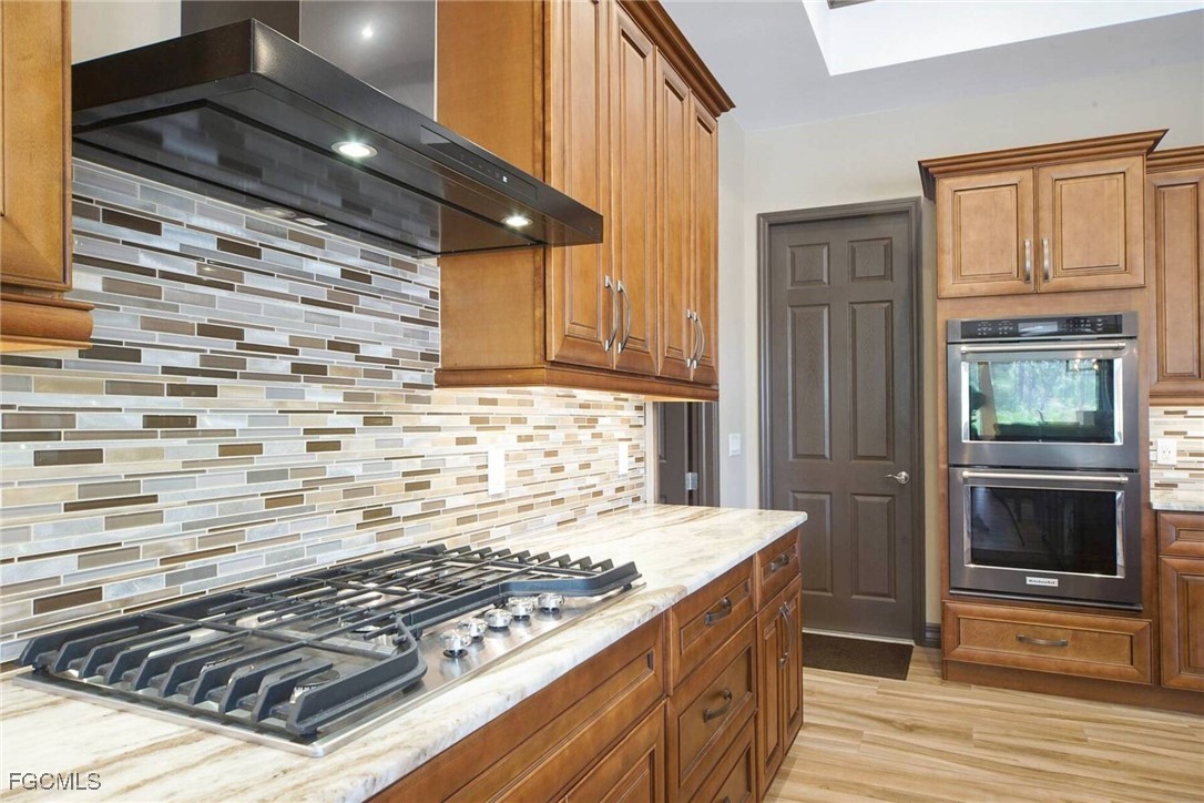 6142 Calusa Rdg Trail Bokeelia, FL 33922 - Photo 8 of 43 a kitchen with granite countertop a stove and a wooden cabinets