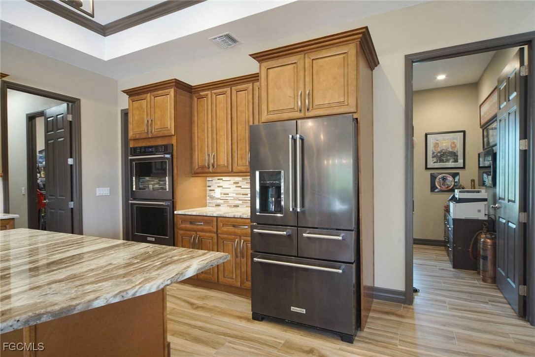 6142 Calusa Rdg Trail Bokeelia, FL 33922 - Photo 10 of 43 a kitchen with stainless steel appliances granite countertop a refrigerator and a stove top oven