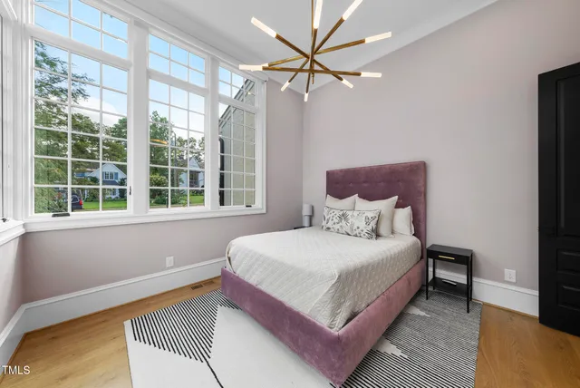 a bedroom with a large bed and a chandelier