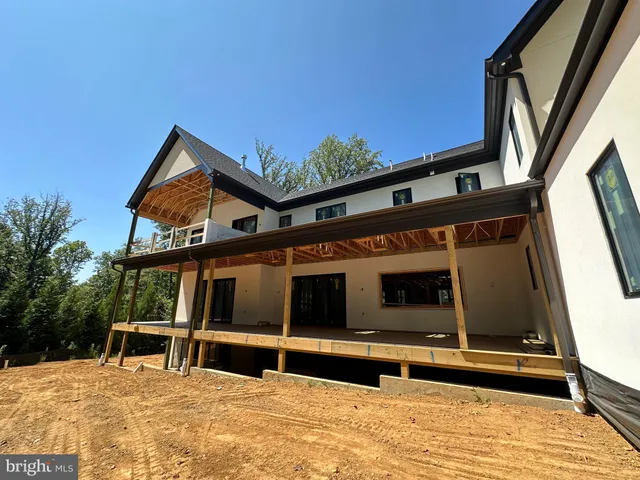 a view of a house with a large window and wooden fence