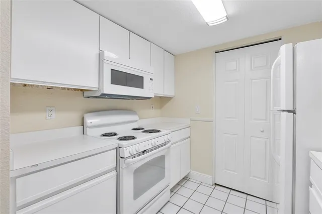 a kitchen with white cabinets and white appliances