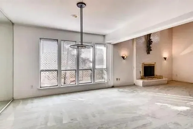 a view of an empty room with a fireplace and a window