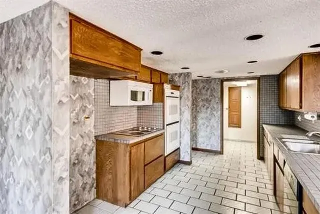 a kitchen with stainless steel appliances granite countertop a stove a sink and a refrigerator