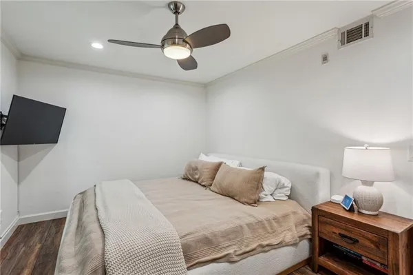 a bedroom with a bed and a flat tv screen on a dresser