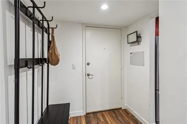 a view of a hallway with wooden floor and entryway
