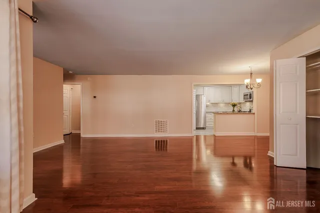 a view of empty room with wooden floor