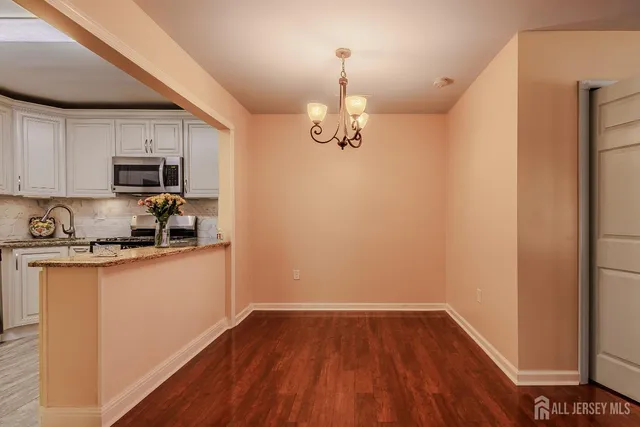 a kitchen with granite countertop wooden floors a sink and a stove
