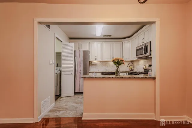 a kitchen with stainless steel appliances granite countertop a refrigerator and a sink
