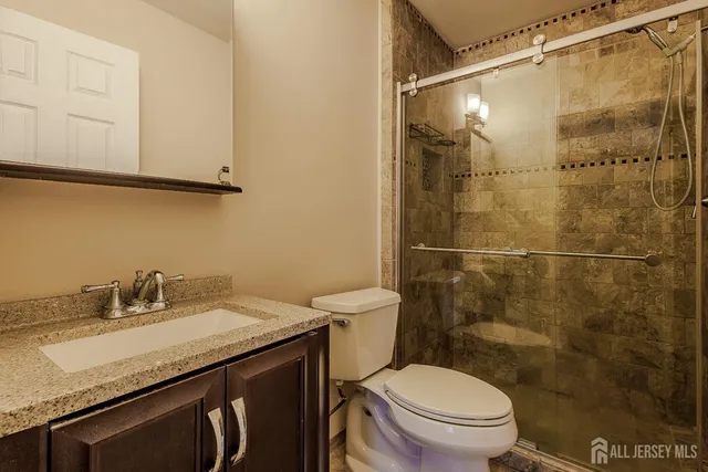 a bathroom with a granite countertop sink toilet and shower