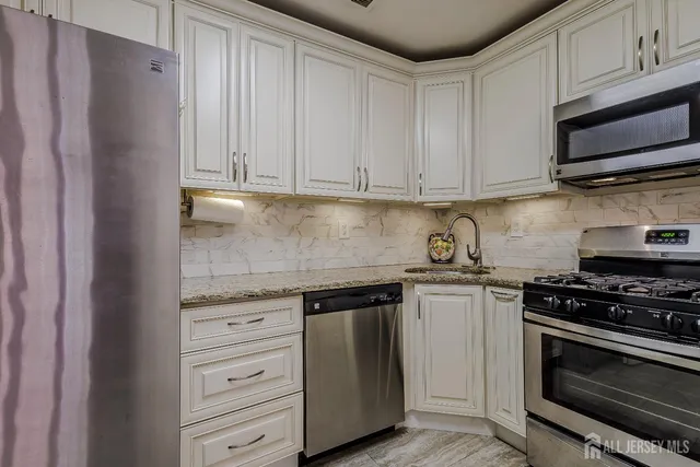 a kitchen with stainless steel appliances granite countertop a stove and a refrigerator