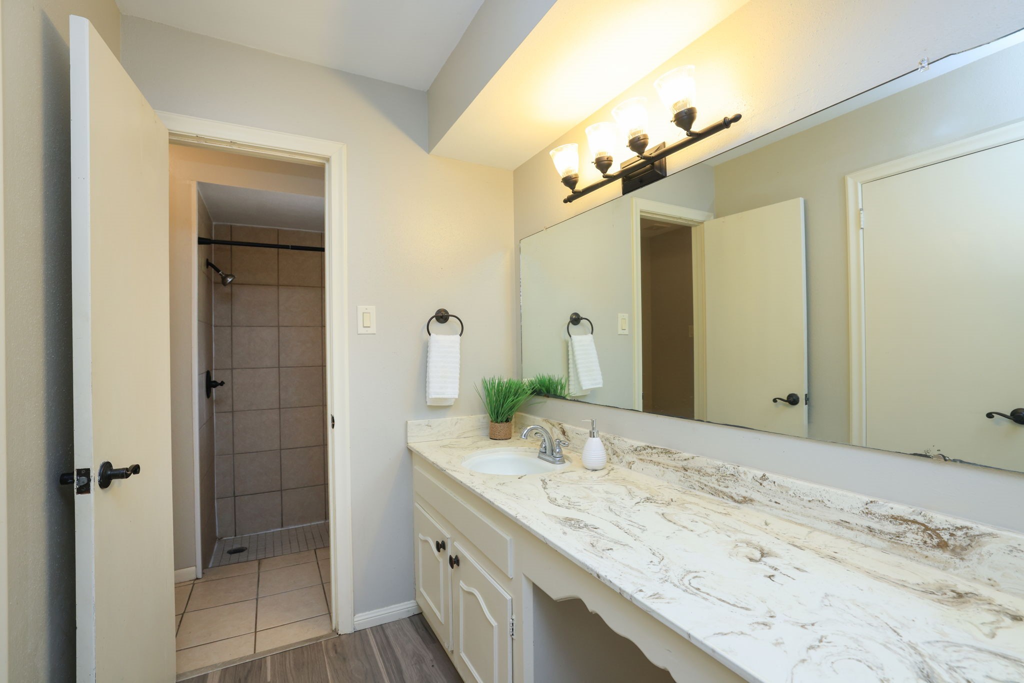 22010 Buescher Road Tomball, TX 77377 - Photo 11 of 30 a bathroom with a granite countertop sink a mirror and a shower