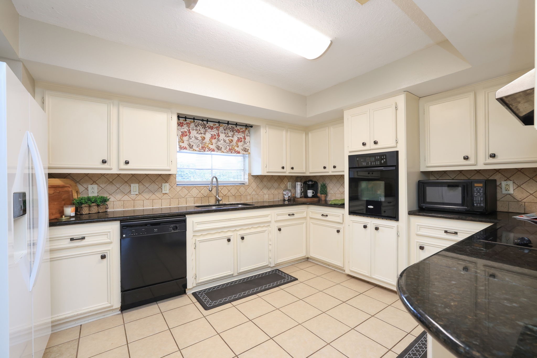 22010 Buescher Road Tomball, TX 77377 - Photo 8 of 30 a kitchen with granite countertop white cabinets and stainless steel appliances