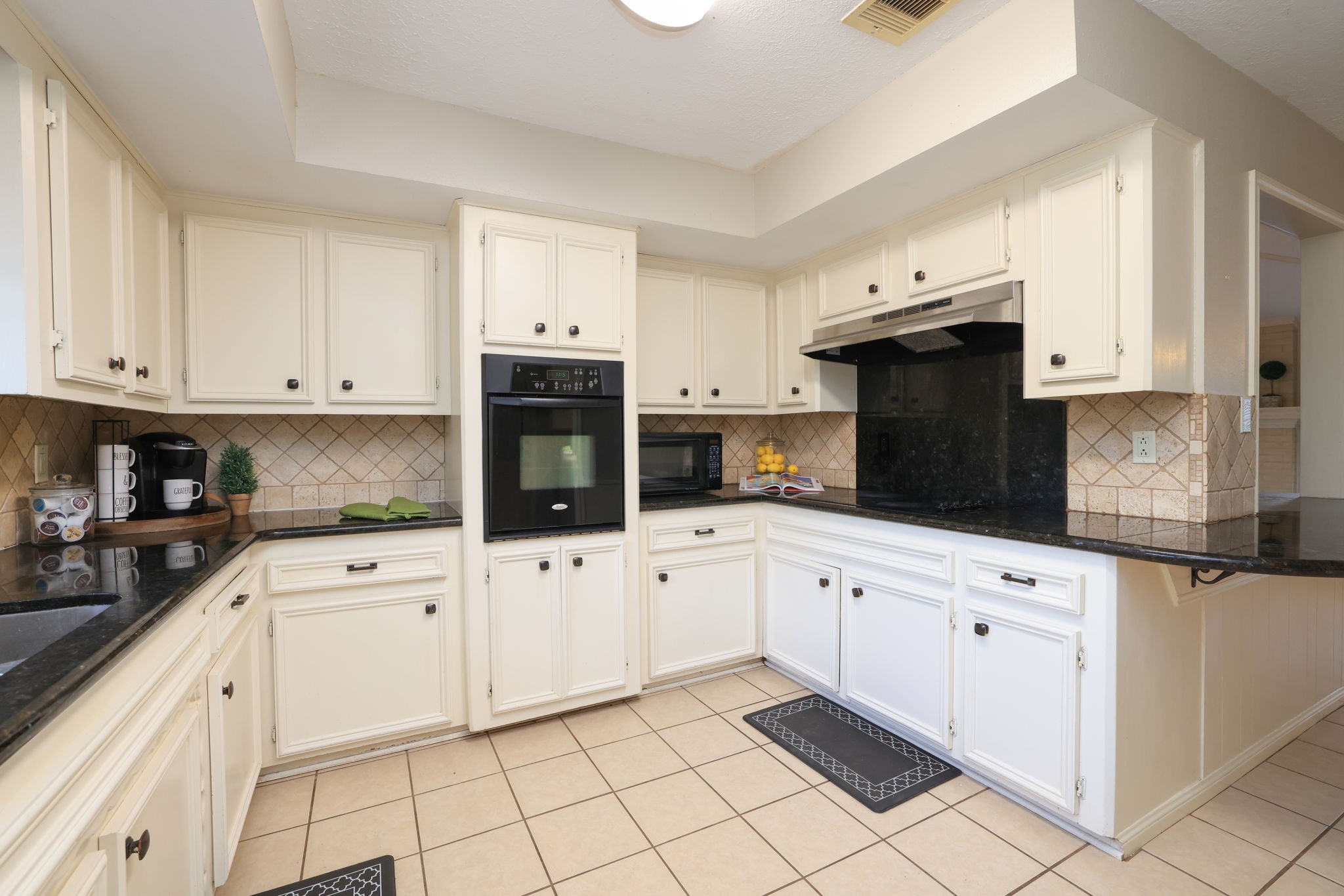 22010 Buescher Road Tomball, TX 77377 - Photo 9 of 30 a kitchen with granite countertop white cabinets and white appliances