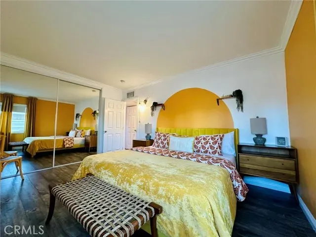 a bedroom with a bed and wooden floor