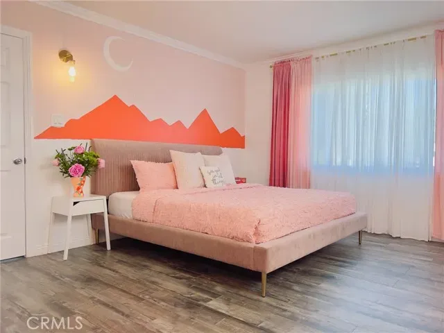 a bedroom with a bed and a painting on the wall