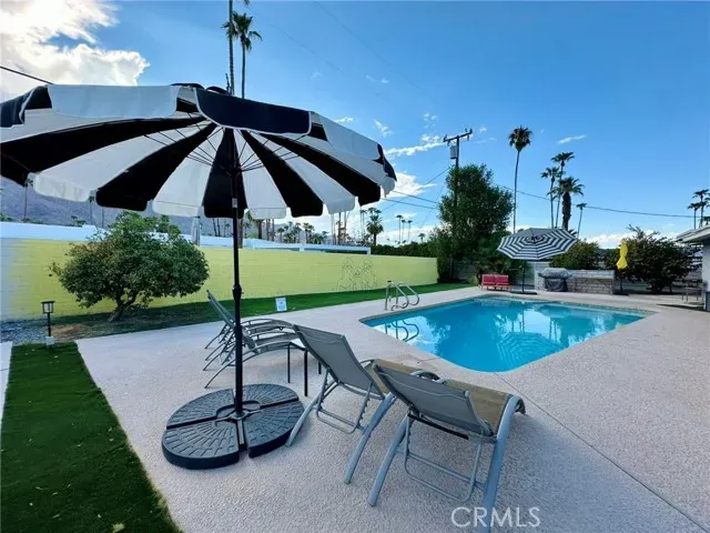 a swimming pool with outdoor seating and yard