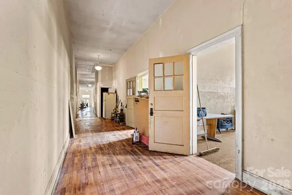 a view of a hallway with wooden floor and white doors