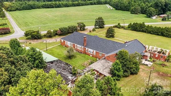 an aerial view of a house with a yard and lake view