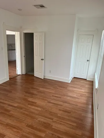 a view of an empty room with wooden floor