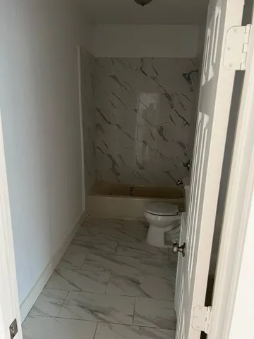 a bathroom with a toilet and a shower