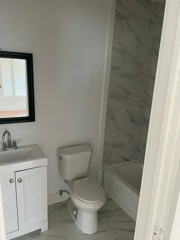 a white toilet sitting next to a bathroom sink