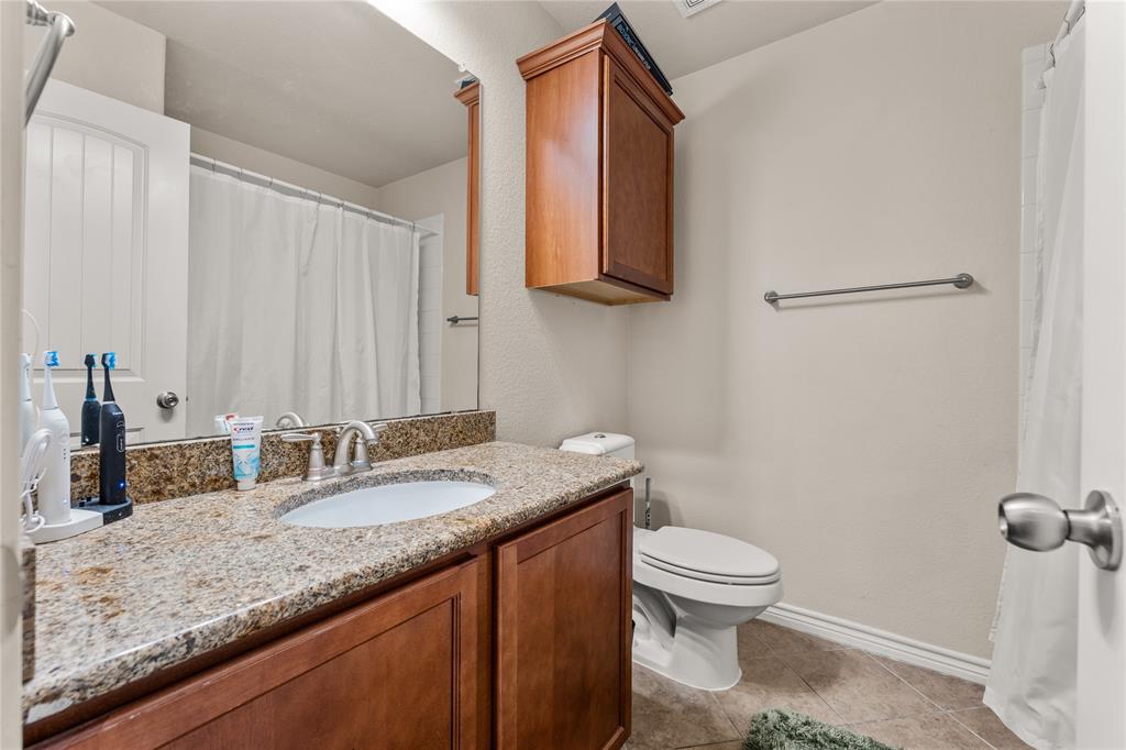 5533 Wisdom Court Waco, TX 76708 - Photo 16 of 21 a bathroom with a granite countertop sink a toilet and mirror