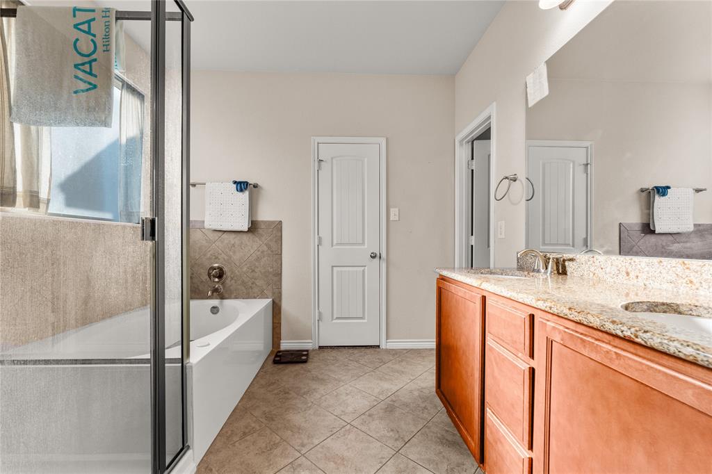 5533 Wisdom Court Waco, TX 76708 - Photo 4 of 21 a bathroom with a granite countertop tub sink and mirror