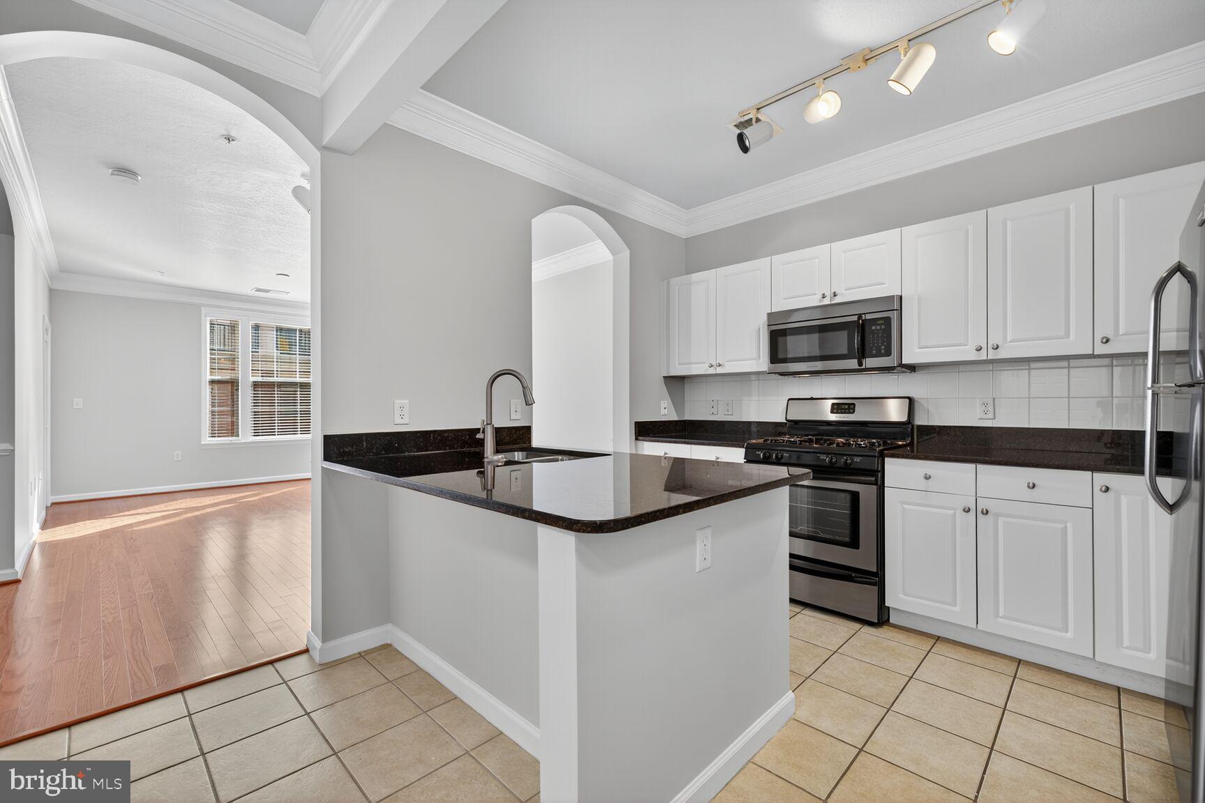 7 Granite Place, Unit 215 Gaithersburg, MD 20878 - Photo 12 of 36 a kitchen with stainless steel appliances granite countertop a sink and a stove