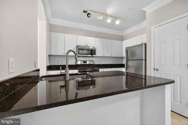 a kitchen with kitchen island a sink stainless steel appliances and counter space