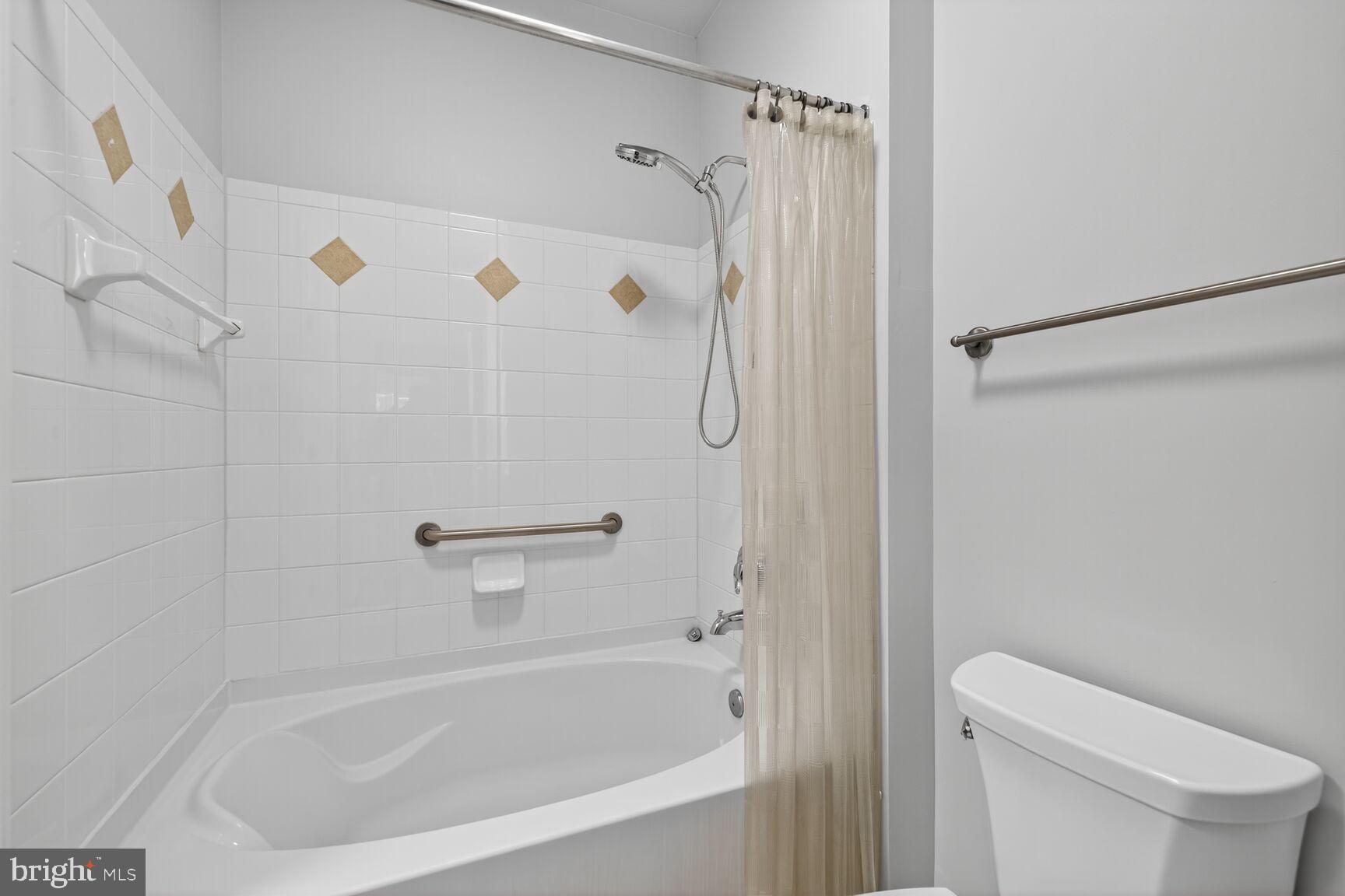 7 Granite Place, Unit 215 Gaithersburg, MD 20878 - Photo 25 of 36 a white bath tub with a shower curtain