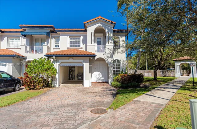a front view of a house with a yard and potted plants