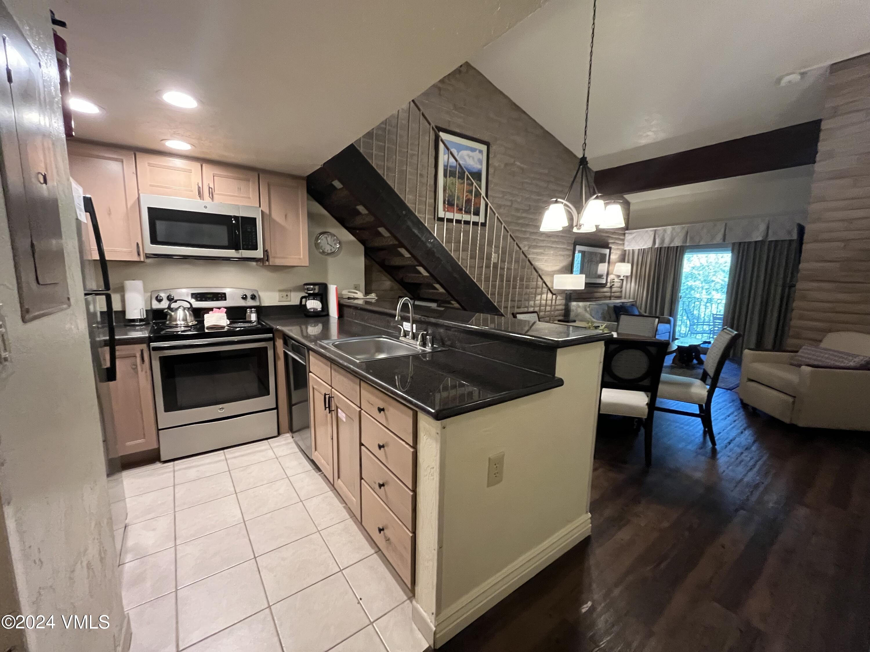 a kitchen with kitchen island granite countertop a sink a counter top space appliances and cabinets