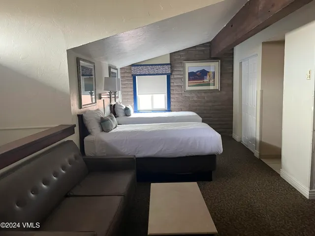 a bed sitting in a bedroom next to a window