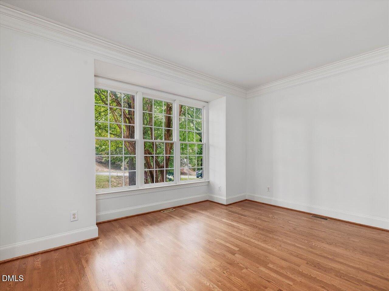 2721 Glassman Lane Raleigh, NC 27606 - Photo 5 of 26 an empty room with wooden floor and windows
