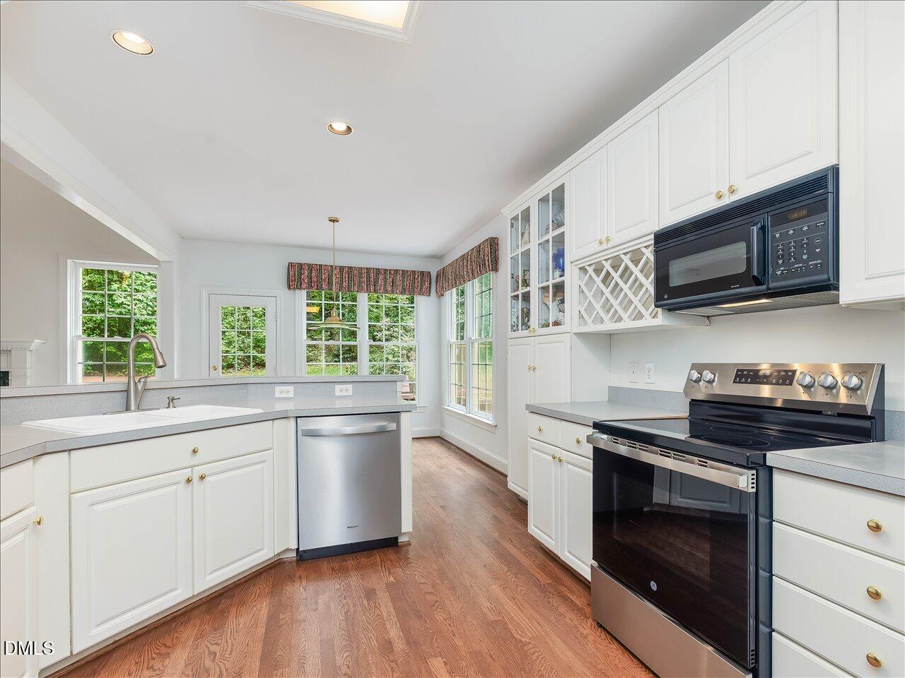 2721 Glassman Lane Raleigh, NC 27606 - Photo 9 of 26 a kitchen with stainless steel appliances a stove sink microwave and cabinets