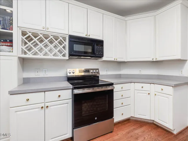 a kitchen with white cabinets and appliances