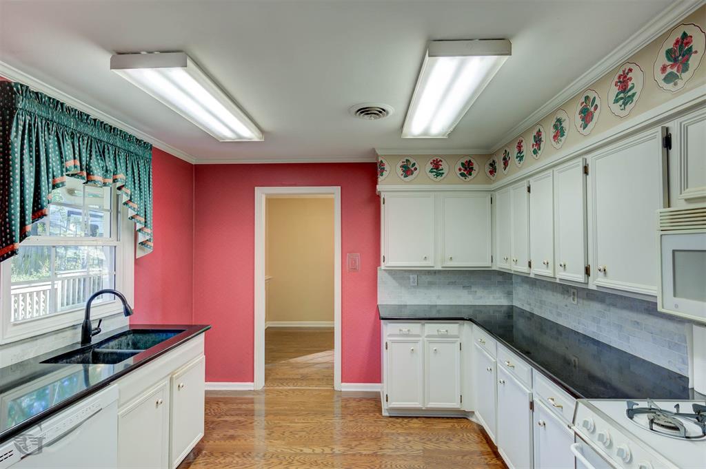 1306 East Todd Street Minden, LA 71055 - Photo 12 of 27 a kitchen with granite countertop a sink stainless steel appliances white cabinets and window