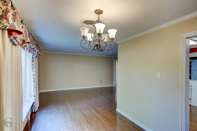 a view of a hallway with chandelier wooden floor and a chandelier