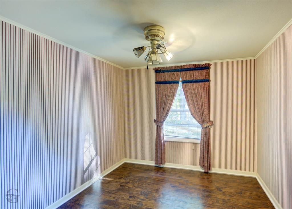 1306 East Todd Street Minden, LA 71055 - Photo 24 of 27 an empty room with wooden floor chandelier fan and windows
