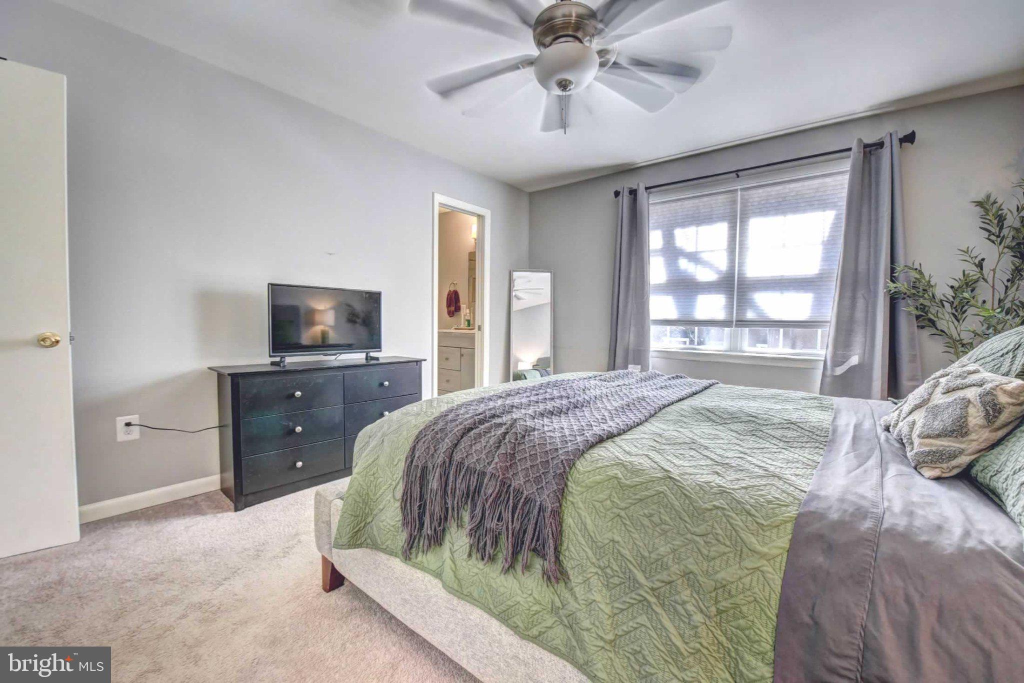 2226 Gunsmith Square Reston, VA 20191 - Photo 17 of 35 a bedroom with a bed and a flat tv screen on dresser